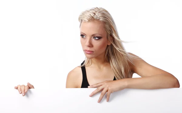 Сексуальна дівчина тримає рекламний щит додати ізольовано на білому фоні — стокове фото