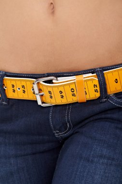 İnce bir kadının karın ve ölçme ile kot portre fotoğrafı