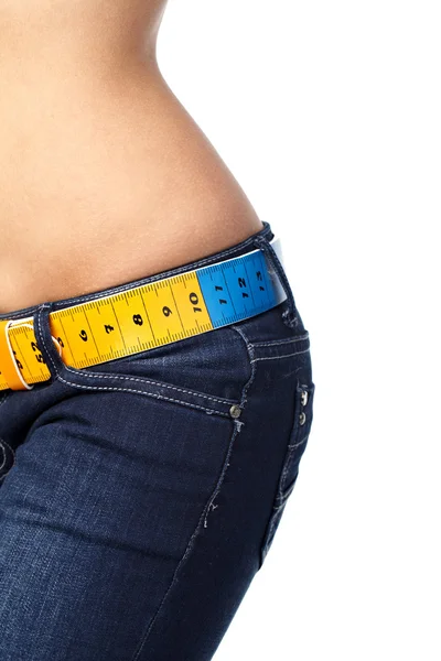 Closeup photo of a slim woman's abdomen and jeans with measuring — Stock Photo, Image