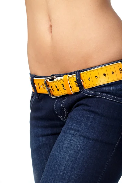 Foto de primer plano del abdomen de una mujer delgada y jeans con medidas — Foto de Stock