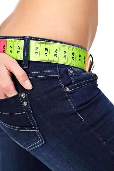 Foto de primer plano del abdomen de una mujer delgada y jeans con medidas —  Fotos de Stock