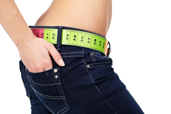 Foto de close-up do abdômen e jeans de uma mulher magra com medição — Fotografia de Stock