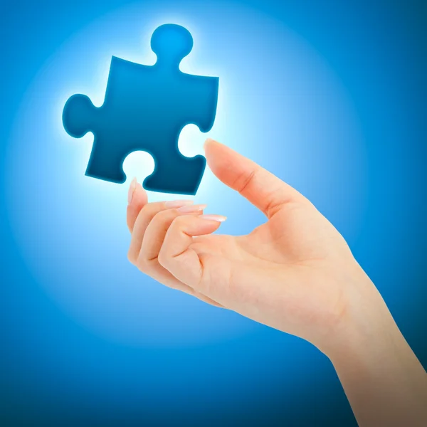 Womanish hand with a puzzle — Stock Photo, Image