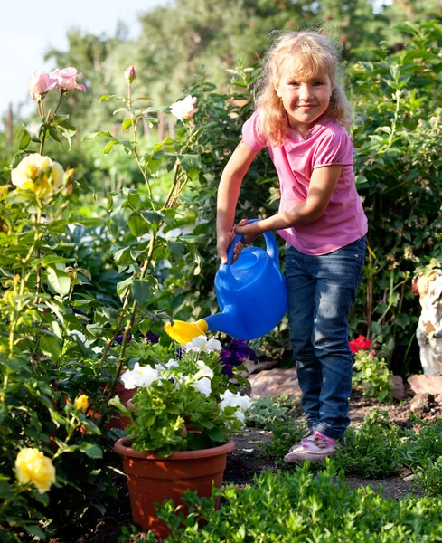 Girl watering flowers are watered from — Stock Photo, Image
