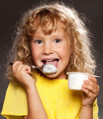 Little girl eating yogurt clipart