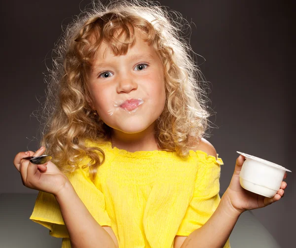 Kislány joghurtot eszik. — Stock Fotó
