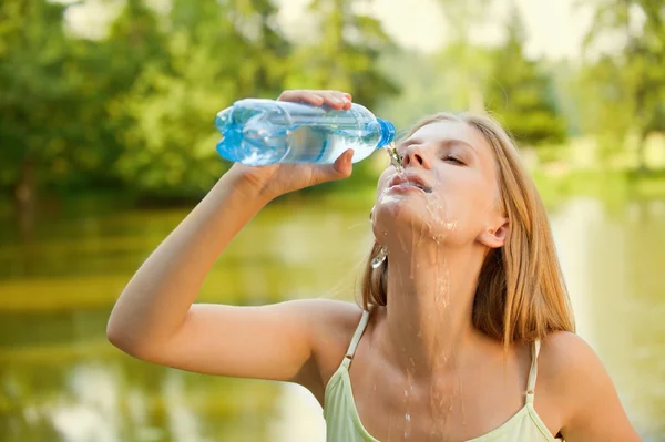 Mujer joven bebe un agua — Foto de Stock