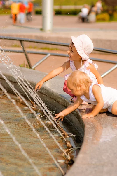 Zusters spelen bij fontein — Stockfoto