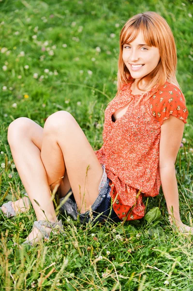 Chica se sienta en la hierba — Foto de Stock