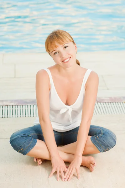 Lachende vrouw in spijkerbroek nabijgelegen zwembad — Stockfoto