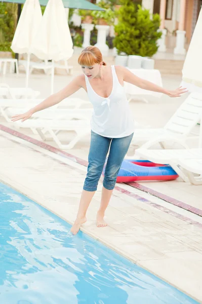 Lachende vrouw in spijkerbroek nabijgelegen zwembad — Stockfoto