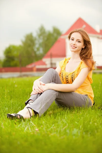 美丽的姑娘坐在草坪上 — 图库照片