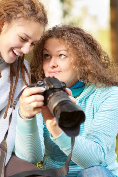 Two girls look through pictures on camera — Stock Photo, Image