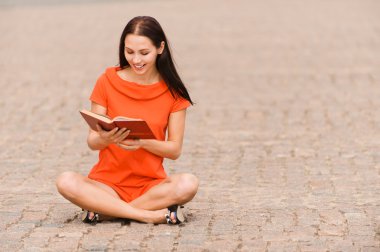 Lovely young woman reads book clipart