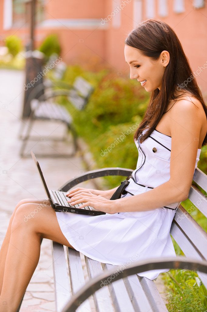Young beautiful brunette with black laptop.