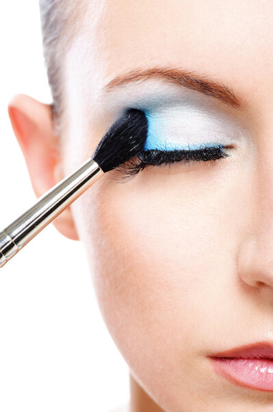 Woman applying blusher eyelid