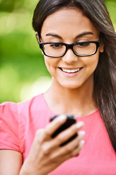 Mujer lee mensaje de texto en el teléfono celular —  Fotos de Stock