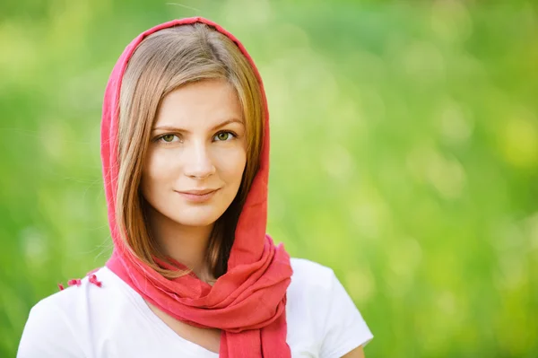 Vrouw in rode hoofddoek glimlacht — Stockfoto
