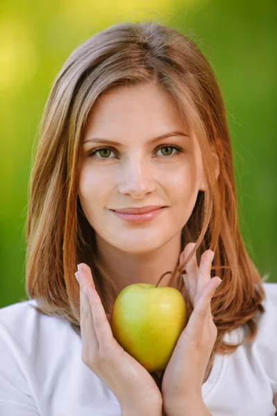 Woman holds apple — Stock Photo, Image