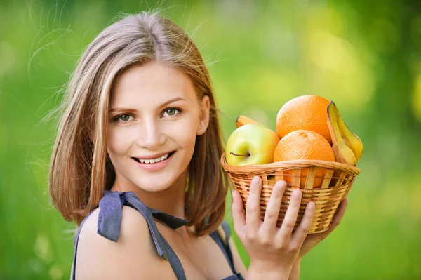 Woman holds basket with fruit — Stock Photo, Image
