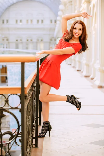 Frau in rotem Kleid über Geländer — Stockfoto