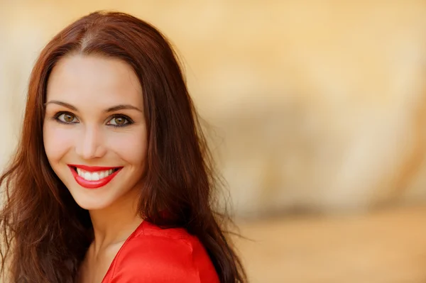 Усміхнена молода жінка в червоній сукні — стокове фото
