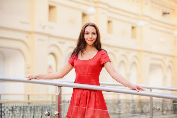 Woman in red dress about handrail — Stock Photo, Image