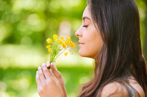Vrouw ruikt gele roosjes — Stockfoto