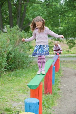 Little cute girl on playground clipart