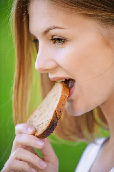 Портрет женщины, поедающей хлеб — стоковое фото