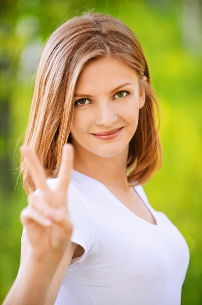 Portrét krásné mladé ženy ukazující vítězství znamení gesto — Stock fotografie