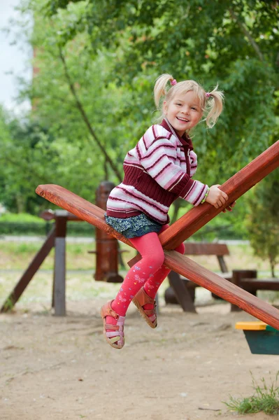 Porträt eines kleinen blonden Mädchens auf der Wippe — Stockfoto