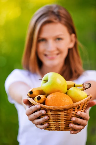 Portrait of woman holding basket with fruits — Stock Photo, Image