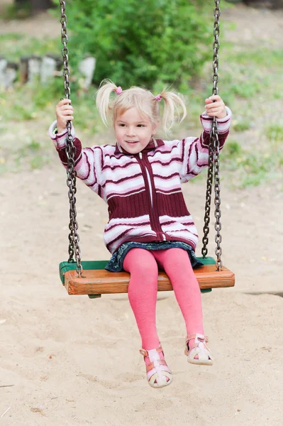 Portrait of a little blond girl on swing — Stock Photo, Image