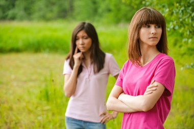 Two beautiful young women in park clipart