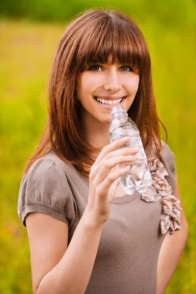 Μικρά χαμογελαστή γυναίκα πόσιμο νερό — Φωτογραφία Αρχείου