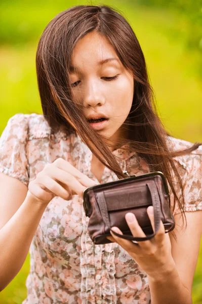 Yong kadın küçük çantasında arıyor — Stok fotoğraf