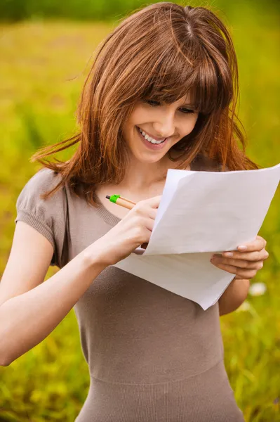 Young beautiful smiling woman writing something — Stock Photo, Image