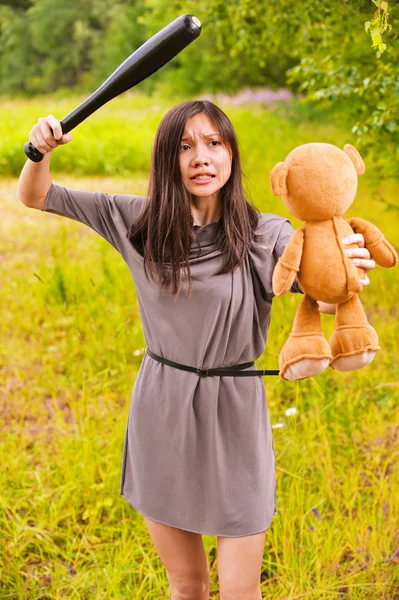 Jovem mulher zangada batendo toybear — Fotografia de Stock