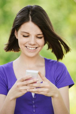 Young smiling woman with mobile phone clipart