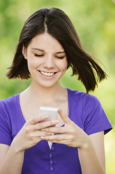 Jonge lachende vrouw met mobiele telefoon — Stockfoto