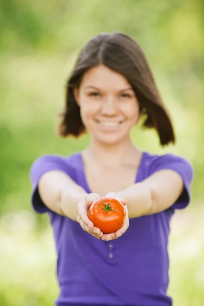 Νεαρή γυναίκα χαρούμενη εκμετάλλευση ντομάτα — Φωτογραφία Αρχείου