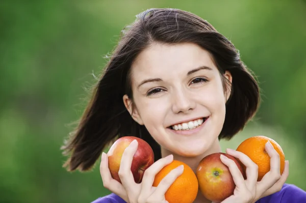 Jeune femme joyeuse tenant des fruits — Photo