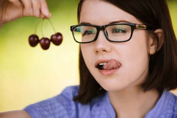Joven mujer pensativa comiendo cerezas — Foto de Stock