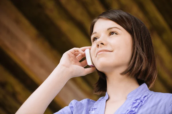 Unga leende kvinna talar på telefon — Stockfoto