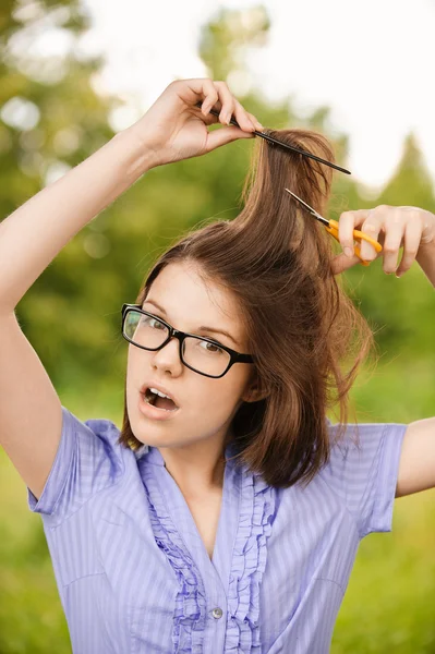 Portrait de jeune femme coupant ses cheveux — Photo