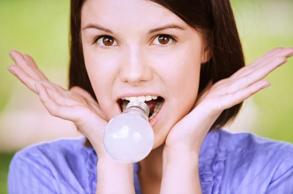 Ritratto di giovane donna divertente con lampadina in bocca — Foto Stock