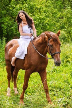 Young beautiful woman rides a horse clipart