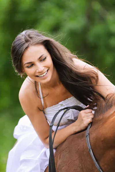 Jonge brunette vrouw rijdt een paard — Stockfoto