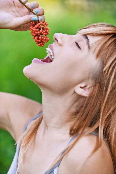 Jovem mulher alegre comendo bagas da floresta — Fotografia de Stock